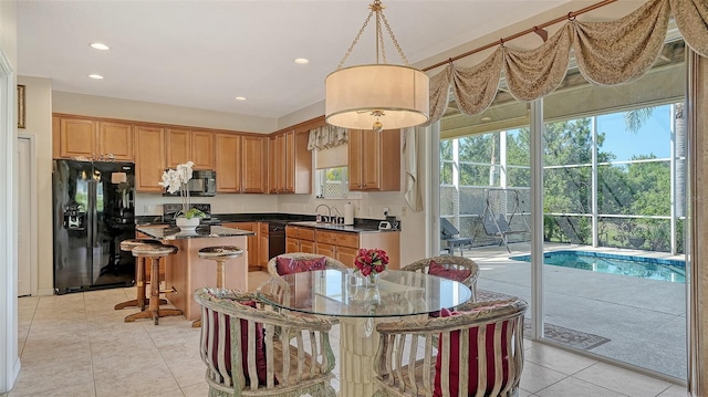 12520 Natureview Cir, Bradenton, FL 34212 - kitchen featuring black appliances, dark countertops, a kitchen island, a sink, and light tile patterned floors