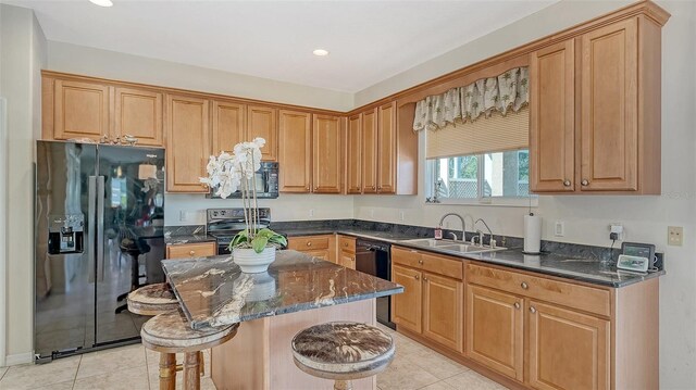 12520 Natureview Cir, Bradenton, FL 34212 - kitchen with black appliances, a sink, light tile patterned flooring, a center island, and dark stone counters