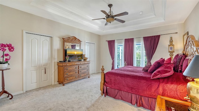 12520 Natureview Cir, Bradenton, FL 34212 - bedroom with a tray ceiling, ornamental molding, light carpet, two closets, and a ceiling fan