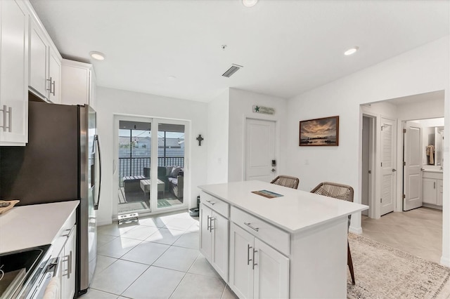 14257 Heritage Landing Blvd Unit 1122, Punta Gorda, FL 33955 - kitchen with stainless steel appliances, light countertops, a kitchen breakfast bar, white cabinets, and a kitchen island