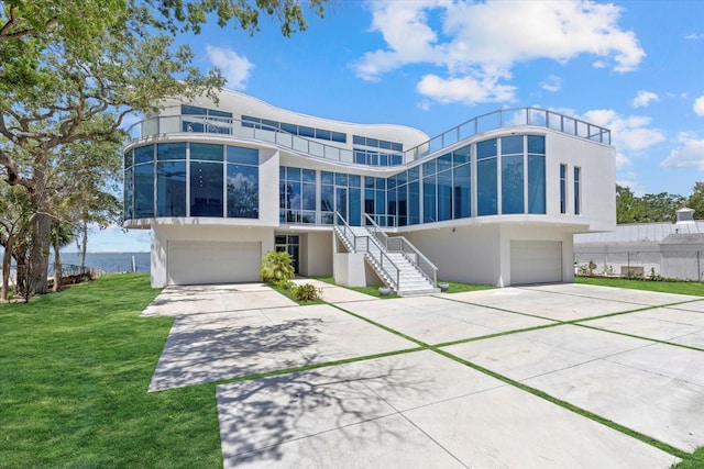 4035 Bay Shore Rd, Sarasota, FL 34234 - rear view of property with a garage, stucco siding, and stairs