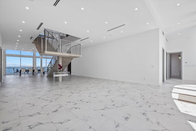 4035 Bay Shore Rd, Sarasota, FL 34234 - unfurnished living room with stairs, a wall of windows, a towering ceiling, recessed lighting, and marble finish floors