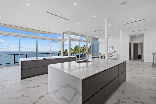 4035 Bay Shore Rd, Sarasota, FL 34234 - kitchen featuring modern cabinets, a spacious island, expansive windows, light marble finish floors, and a water view