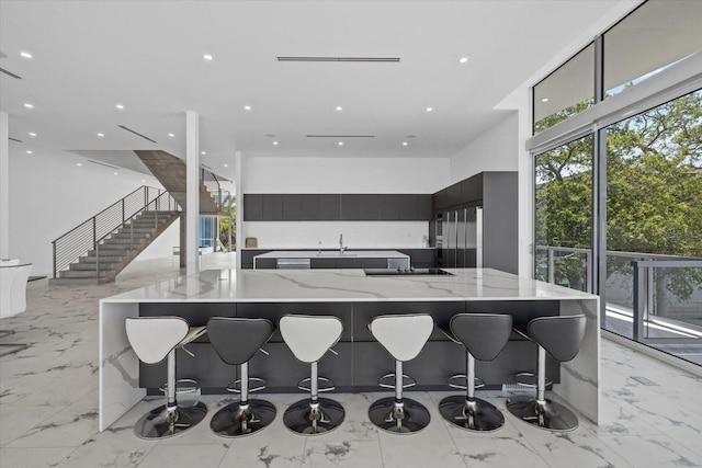 4035 Bay Shore Rd, Sarasota, FL 34234 - kitchen with modern cabinets, light stone countertops, high end fridge, light marble finish flooring, and a high ceiling