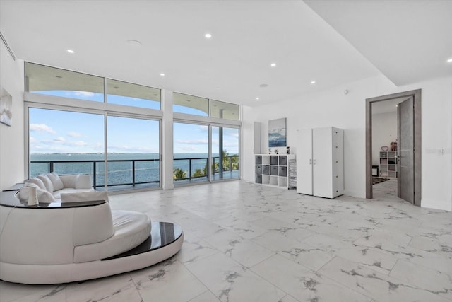 4035 Bay Shore Rd, Sarasota, FL 34234 - living room featuring a water view, a wall of windows, a towering ceiling, recessed lighting, and light marble finish flooring