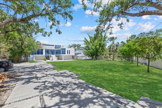 4035 Bay Shore Rd, Sarasota, FL 34234 - view of grassy yard with an attached garage, concrete driveway, and a sunroom