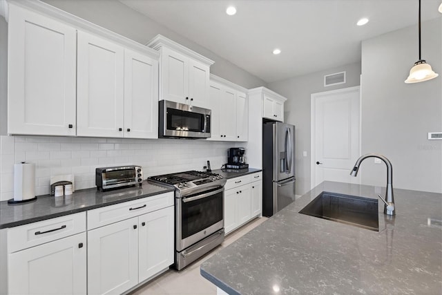 13549 Old Creek Ct, Parrish, FL 34219 - kitchen featuring appliances with stainless steel finishes, a sink, decorative backsplash, white cabinetry, and recessed lighting