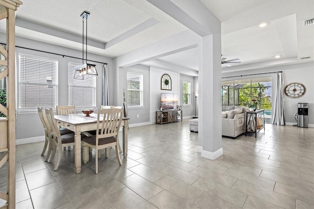 17547 Cantarina Cv, Bradenton, FL 34211 - dining area with a tray ceiling, baseboards, a chandelier, a ceiling fan, and light tile patterned floors