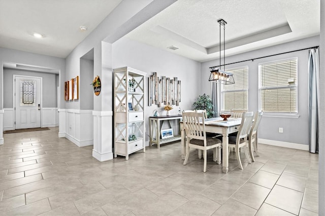 17547 Cantarina Cv, Bradenton, FL 34211 - dining area with plenty of natural light, a chandelier, a textured ceiling, and a tray ceiling