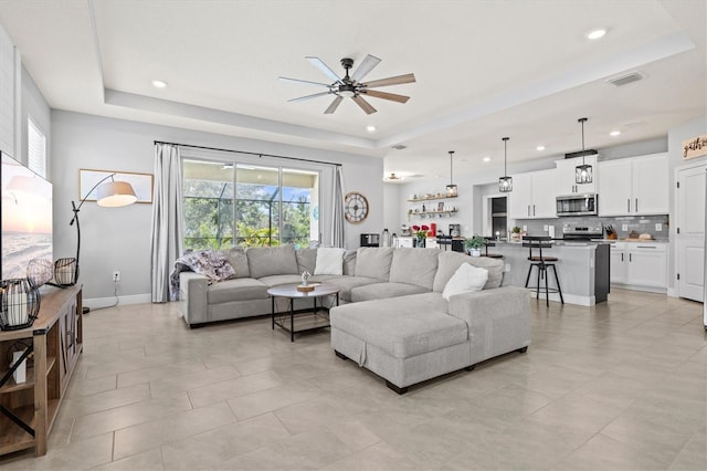 17547 Cantarina Cv, Bradenton, FL 34211 - living room featuring a tray ceiling, ceiling fan, recessed lighting, baseboards, and light tile patterned floors