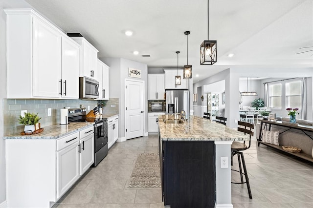 17547 Cantarina Cv, Bradenton, FL 34211 - kitchen with stainless steel appliances, a sink, tasteful backsplash, a breakfast bar, and recessed lighting