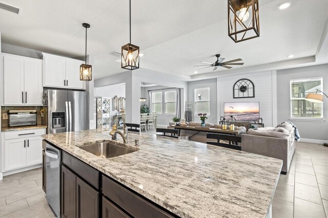 17547 Cantarina Cv, Bradenton, FL 34211 - kitchen with stainless steel appliances, a sink, light tile patterned flooring, light stone counters, and recessed lighting