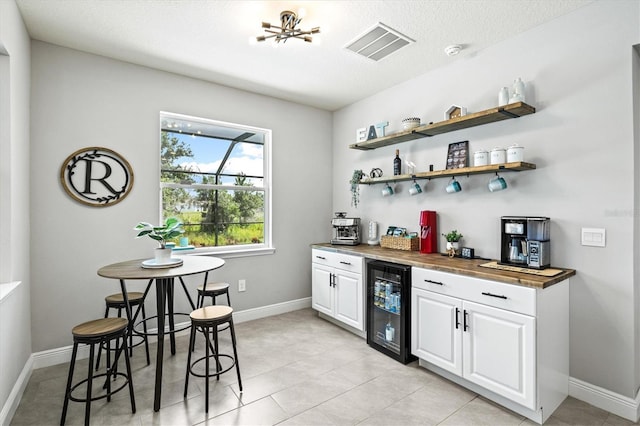 17547 Cantarina Cv, Bradenton, FL 34211 - indoor dry bar featuring beverage cooler, baseboards, and light tile patterned floors