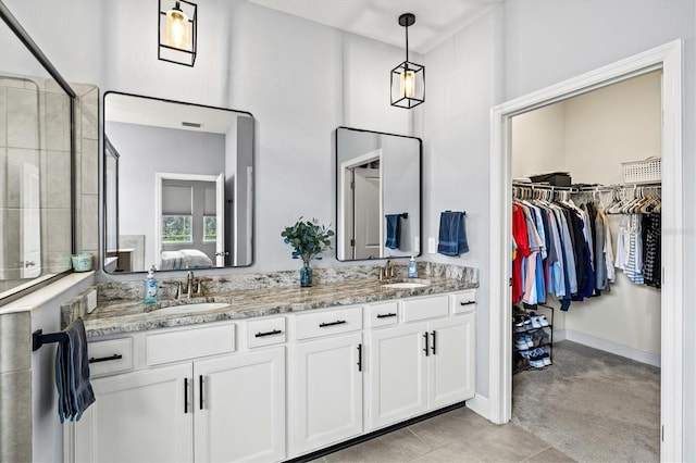 17547 Cantarina Cv, Bradenton, FL 34211 - full bathroom with double vanity, ensuite bathroom, a spacious closet, a tile shower, and baseboards