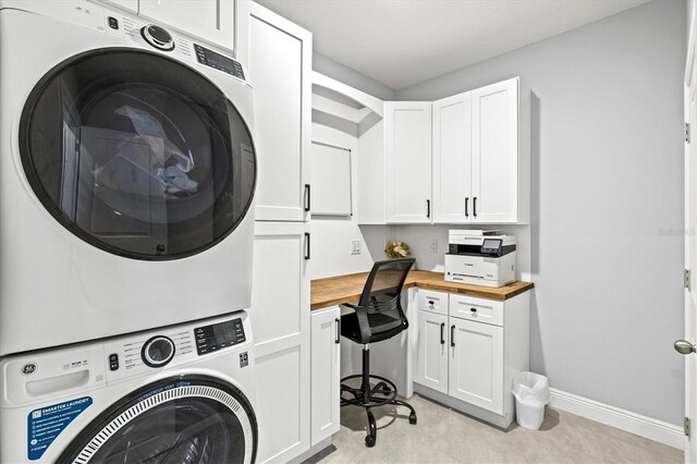 17547 Cantarina Cv, Bradenton, FL 34211 - laundry room with stacked washing machine and dryer, cabinet space, baseboards, and a desk