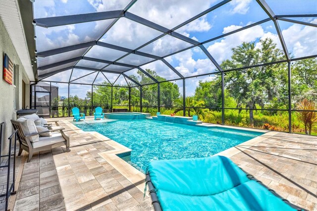 17547 Cantarina Cv, Bradenton, FL 34211 - outdoor pool featuring a patio, view of wooded area, and glass enclosure