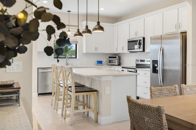 6239 Baywood Ct, Bradenton, FL 34211 - kitchen with appliances with stainless steel finishes, tasteful backsplash, a kitchen breakfast bar, light countertops, and recessed lighting