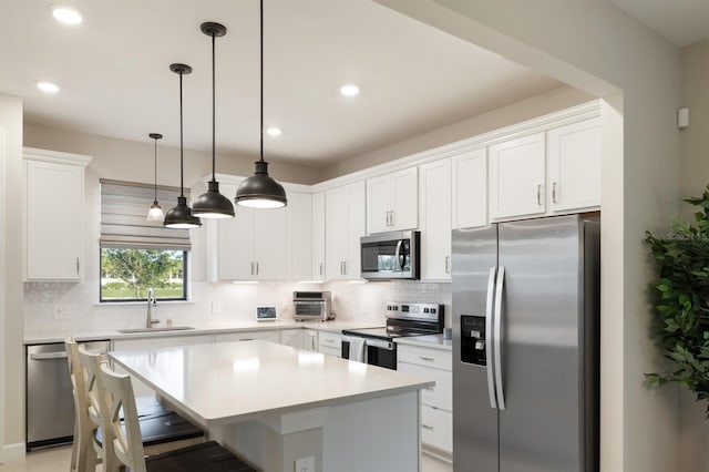 6239 Baywood Ct, Bradenton, FL 34211 - kitchen with stainless steel appliances, backsplash, white cabinets, a breakfast bar, and a kitchen island