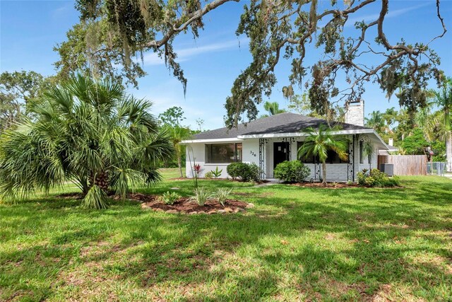 326 25th St W, Bradenton, FL 34205 - view of front facade featuring a chimney and central AC