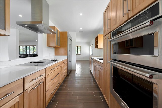 326 25th St W, Bradenton, FL 34205 - kitchen featuring island exhaust hood, double oven, light countertops, glass insert cabinets, and recessed lighting