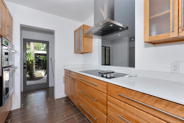 326 25th St W, Bradenton, FL 34205 - kitchen featuring island range hood, electric stovetop, light countertops, glass insert cabinets, and wood tiled floors