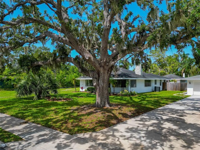 326 25th St W, Bradenton, FL 34205 - ranch-style house featuring a garage, a chimney, driveway, and central AC