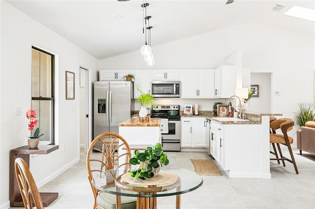 4253 Prairie View Dr, Sarasota, FL 34232 - kitchen featuring stainless steel appliances, vaulted ceiling, a sink, a peninsula, and a breakfast bar area
