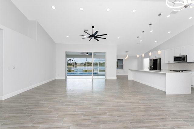 10055 Franklin Dr, Englewood, FL 34224 - unfurnished living room featuring ceiling fan, baseboards, recessed lighting, light wood-style flooring, and high vaulted ceiling