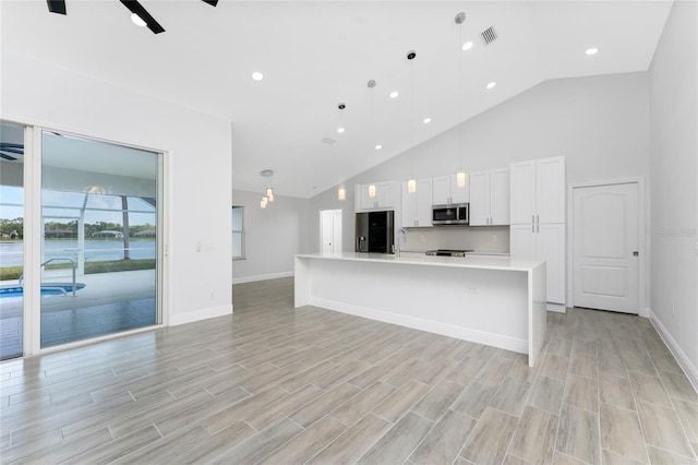 10055 Franklin Dr, Englewood, FL 34224 - kitchen featuring stainless steel appliances, baseboards, high vaulted ceiling, white cabinetry, and light countertops
