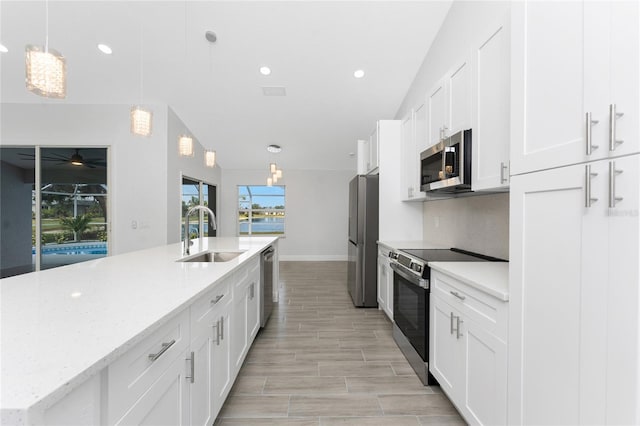 10055 Franklin Dr, Englewood, FL 34224 - kitchen with a sink, appliances with stainless steel finishes, a spacious island, white cabinets, and recessed lighting