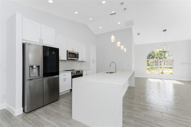 10055 Franklin Dr, Englewood, FL 34224 - kitchen featuring appliances with stainless steel finishes, wood tiled floors, white cabinetry, a sink, and high vaulted ceiling