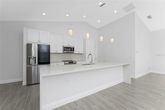 10055 Franklin Dr, Englewood, FL 34224 - kitchen featuring appliances with stainless steel finishes, a sink, high vaulted ceiling, light wood-type flooring, and baseboards