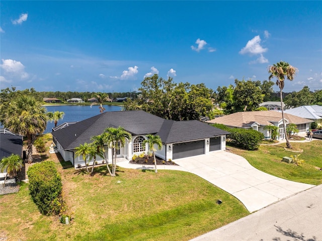10055 Franklin Dr, Englewood, FL 34224 - view of front facade with a garage, driveway, a front lawn, and a water view