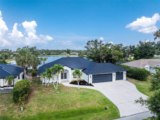 10055 Franklin Dr, Englewood, FL 34224 - view of front of house featuring a garage, concrete driveway, a front lawn, a water view, and a shingled roof