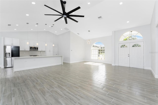 10055 Franklin Dr, Englewood, FL 34224 - unfurnished living room with high vaulted ceiling, recessed lighting, baseboards, light wood-style flooring, and a ceiling fan
