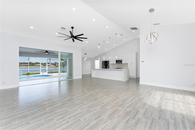10055 Franklin Dr, Englewood, FL 34224 - unfurnished living room with high vaulted ceiling, recessed lighting, baseboards, ceiling fan, and a chandelier