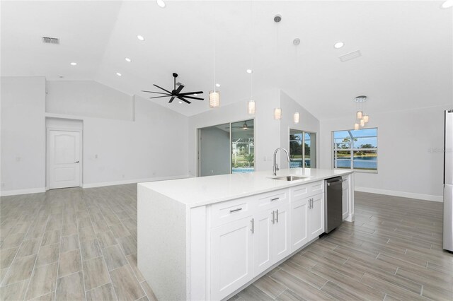 10055 Franklin Dr, Englewood, FL 34224 - kitchen featuring a sink, vaulted ceiling, light countertops, a center island with sink, and white cabinets