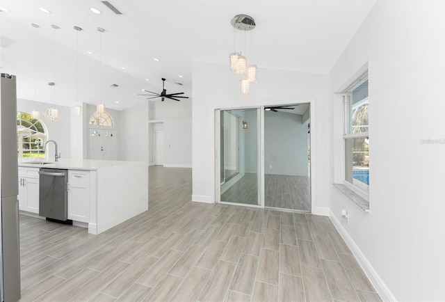 10055 Franklin Dr, Englewood, FL 34224 - kitchen featuring stainless steel dishwasher, lofted ceiling, a ceiling fan, open floor plan, and white cabinetry