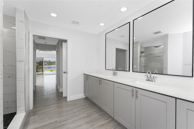 10055 Franklin Dr, Englewood, FL 34224 - full bathroom with a marble finish shower, baseboards, double vanity, recessed lighting, and wood tiled floors
