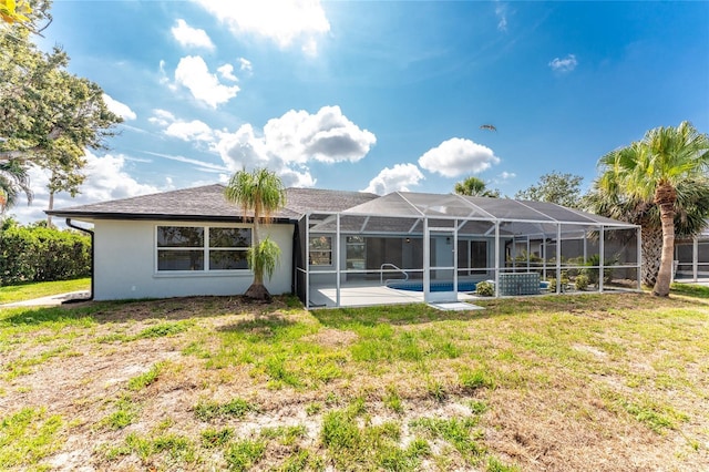 10055 Franklin Dr, Englewood, FL 34224 - back of house with stucco siding, a lawn, and glass enclosure