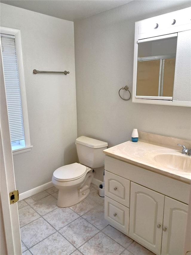 204 36th St W, Bradenton, FL 34205 - full bath with vanity, toilet, baseboards, tile patterned flooring, and an enclosed shower