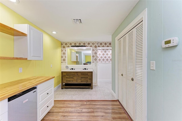 2726 Desoto Rd, Sarasota, FL 34234 - bathroom featuring a closet, vanity, wallpapered walls, wood finished floors, and baseboards