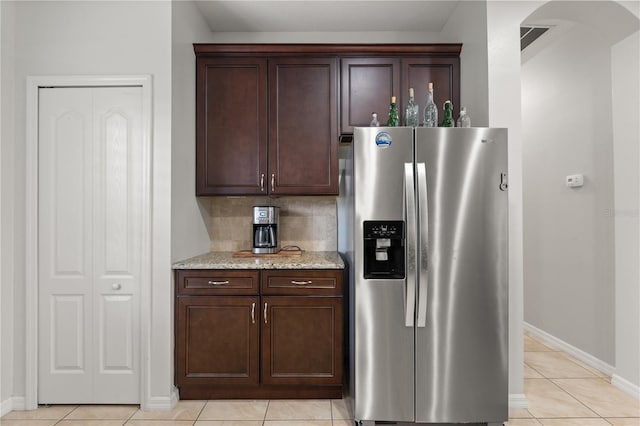 5047 Newport News Cir, Bradenton, FL 34211 - kitchen with stainless steel fridge with ice dispenser, arched walkways, baseboards, light stone countertops, and light tile patterned floors