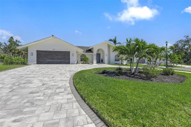 1527 Buoy Ln, Osprey, FL 34229 - ranch-style home featuring decorative driveway, a front yard, an attached garage, and stucco siding