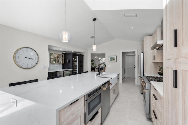 1527 Buoy Ln, Osprey, FL 34229 - kitchen with stainless steel appliances, a sink, light brown cabinetry, vaulted ceiling, and light stone counters