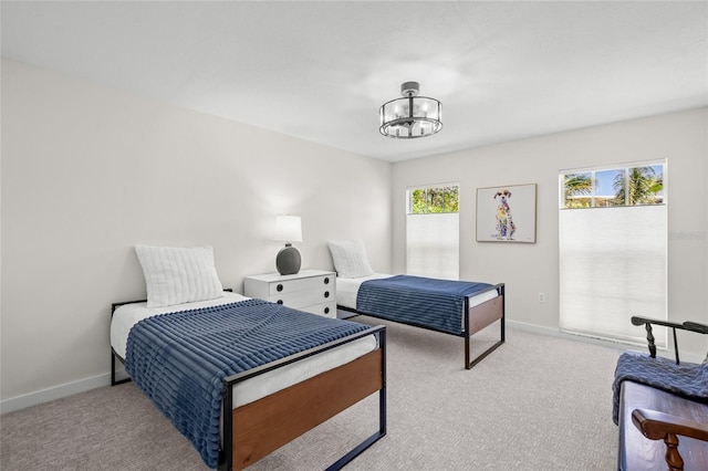 1527 Buoy Ln, Osprey, FL 34229 - bedroom with light colored carpet, multiple windows, a chandelier, and baseboards