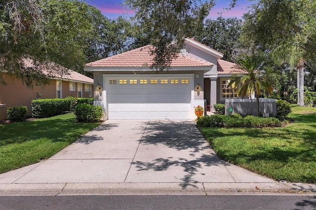 4121 Reflections Pkwy, Sarasota, FL 34233 - mediterranean / spanish-style house featuring concrete driveway, an attached garage, a lawn, and stucco siding