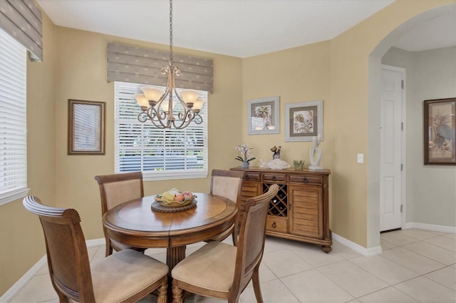 4121 Reflections Pkwy, Sarasota, FL 34233 - dining area featuring arched walkways, a chandelier, light tile patterned floors, and baseboards