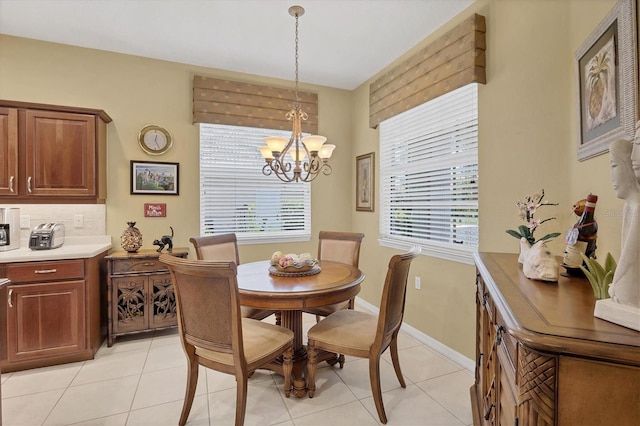 4121 Reflections Pkwy, Sarasota, FL 34233 - dining space featuring a chandelier, light tile patterned floors, and baseboards