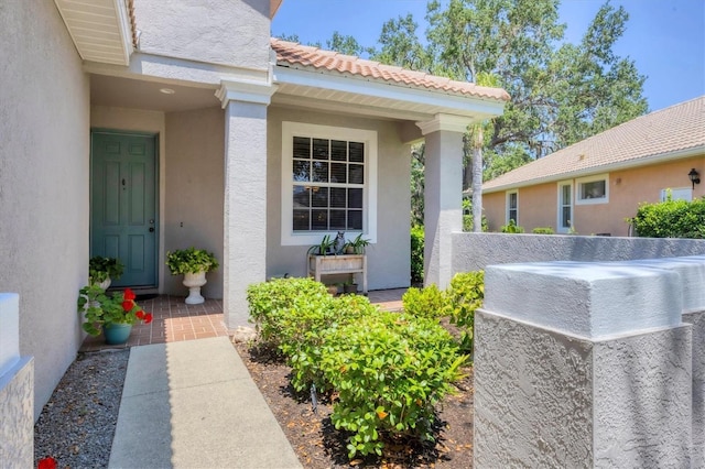 4121 Reflections Pkwy, Sarasota, FL 34233 - view of exterior entry featuring stucco siding and a tiled roof